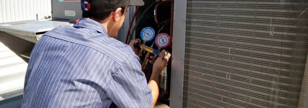 HVAC technician servicing a condenser unit in Bennettsville