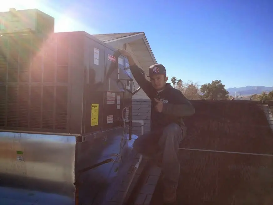 HVAC technician performing Air Duct Cleaning on a rooftop unit in Bennettsville